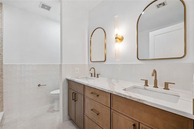 90 Bay Street Lndg Unit 6L, Staten Island, NY 10301 - full bath with tile walls, toilet, double vanity, wainscoting, and tile patterned flooring