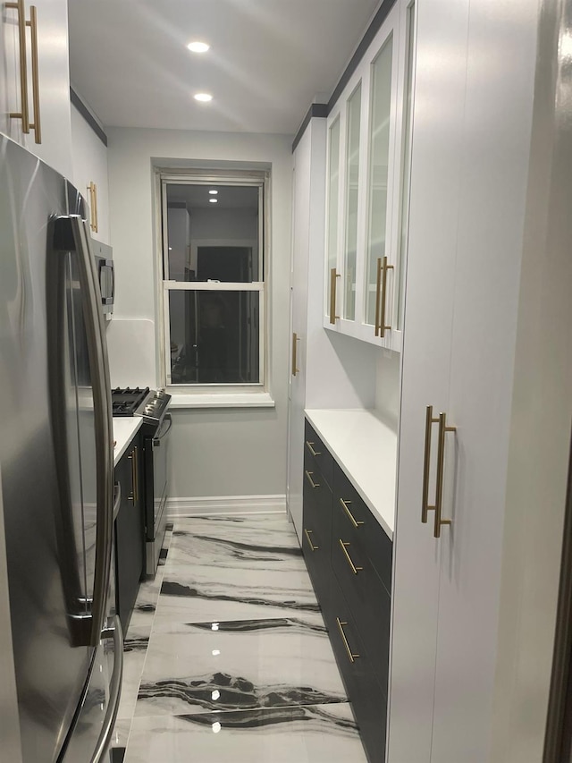 67-66 108th St Unit D5, Forest Hills, NY 11375 - kitchen featuring freestanding refrigerator, light marble finish floors, baseboards, gas stove, and light countertops