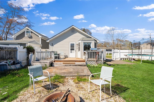 244 Laverne Ave, Holbrook, NY 11741 - back of house featuring a trampoline, a wooden deck, and an outdoor fire pit