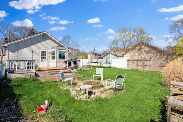 244 Laverne Ave, Holbrook, NY 11741 - view of yard with a trampoline, a wooden deck, and an outdoor fire pit