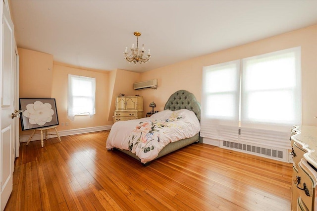 136 Linden St, Woodmere, NY 11598 - bedroom featuring a wall mounted air conditioner, a chandelier, light wood-style flooring, and baseboards