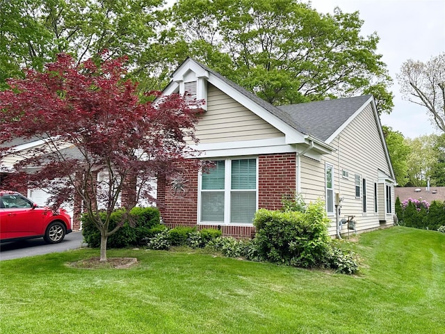 5 Baldwin Ct, Ridge, NY 11961 - view of front facade featuring a front yard, brick siding, driveway, and roof with shingles