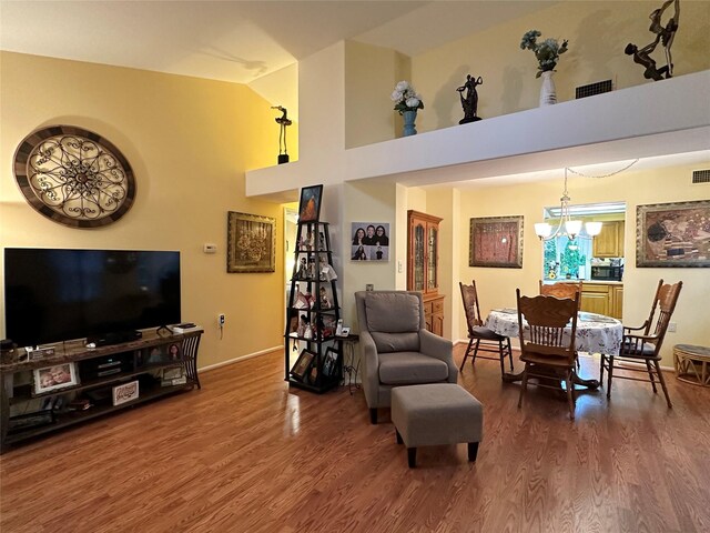 5 Baldwin Ct, Ridge, NY 11961 - living area with a chandelier, wood finished floors, vaulted ceiling, and baseboards