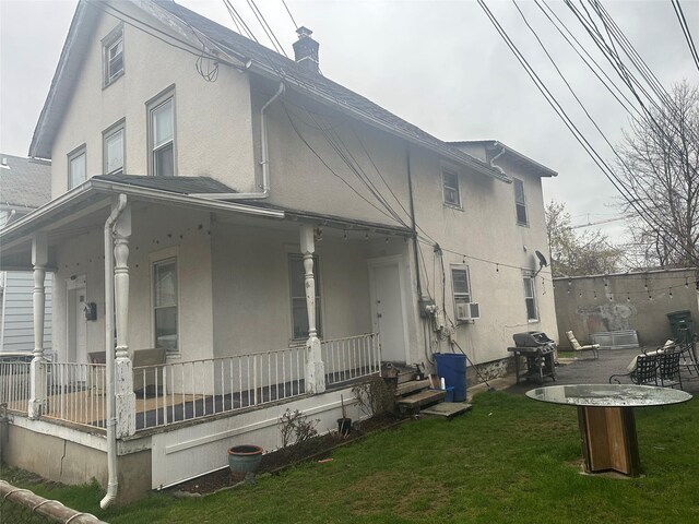 43 Oak St, Port Chester, NY 10573 - view of home's exterior with a porch, a lawn, a chimney, stucco siding, and cooling unit