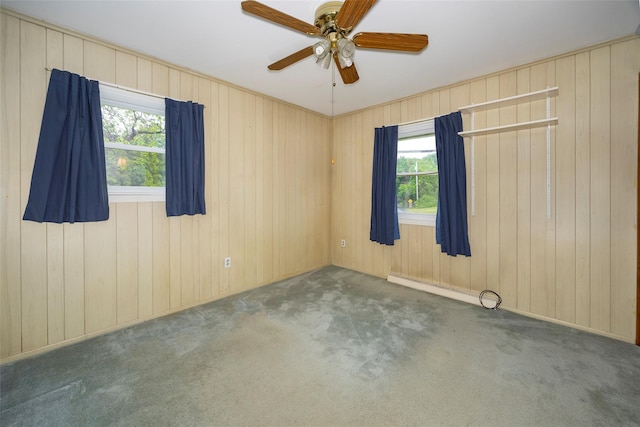 7 Sycamore Dr, Hyde Park, NY 12538 - carpeted empty room featuring plenty of natural light, ceiling fan, a baseboard radiator, and wooden walls