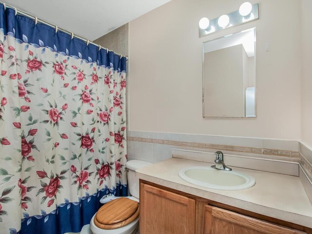 105 Surf Dr Unit 25, Bronx, NY 10473 - bathroom featuring vanity, toilet, tile walls, curtained shower, and a wainscoted wall