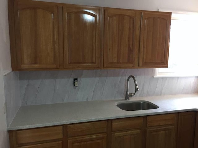 17 Chestnut St, Yonkers, NY 10701 - kitchen featuring a sink, decorative backsplash, and brown cabinets