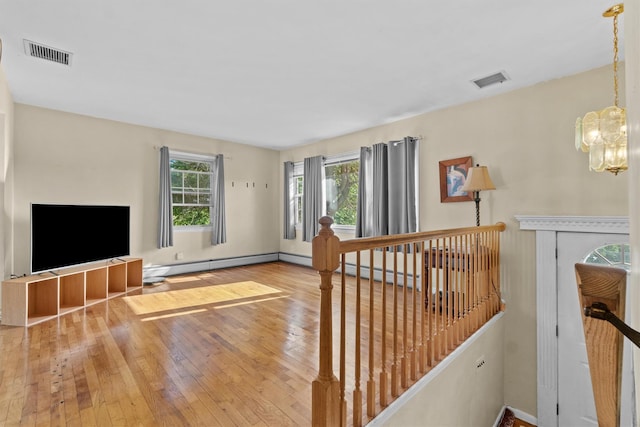 37 Lakeview Rd, Carmel, NY 10512 - unfurnished living room with hardwood / wood-style flooring, a chandelier, and a baseboard heating unit
