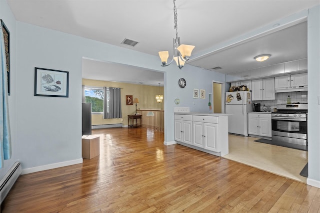 37 Lakeview Rd, Carmel, NY 10512 - kitchen featuring stainless steel range with gas cooktop, freestanding refrigerator, a baseboard heating unit, a baseboard radiator, and a chandelier