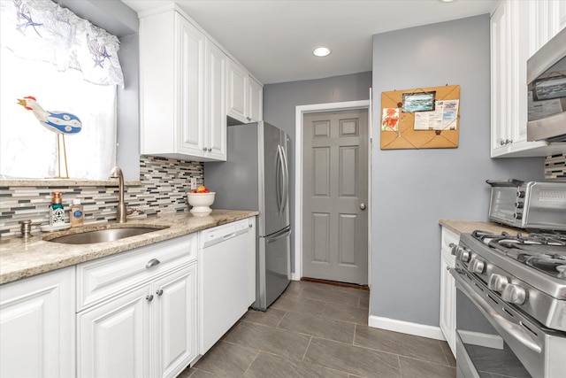 333 E Broadway Unit 1D, Long Beach, NY 11561 - kitchen with stainless steel appliances, a sink, tasteful backsplash, white cabinets, and light stone countertops