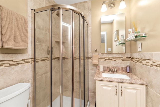 333 E Broadway Unit 1D, Long Beach, NY 11561 - bathroom with tile walls, toilet, vanity, a shower stall, and wainscoting
