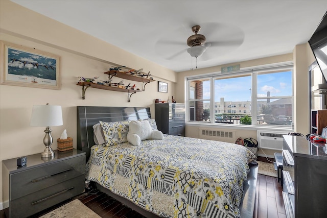 333 E Broadway Unit 1D, Long Beach, NY 11561 - bedroom with radiator heating unit, wood-type flooring, an AC wall unit, and a ceiling fan