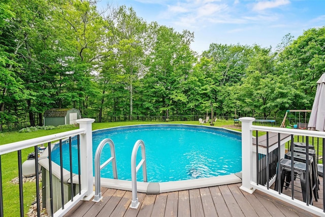 65 Awosting Rd, Pine Bush, NY 12566 - view of pool featuring a deck, view of wooded area, and a playground