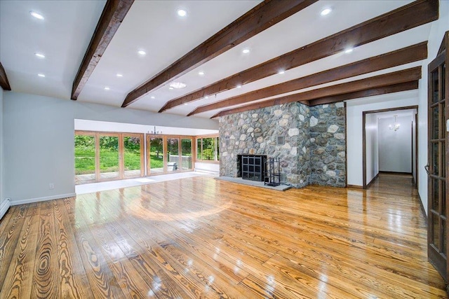 665 State Route 94 N, Warwick, NY 10990 - unfurnished living room featuring beam ceiling, wood-type flooring, a stone fireplace, and baseboards
