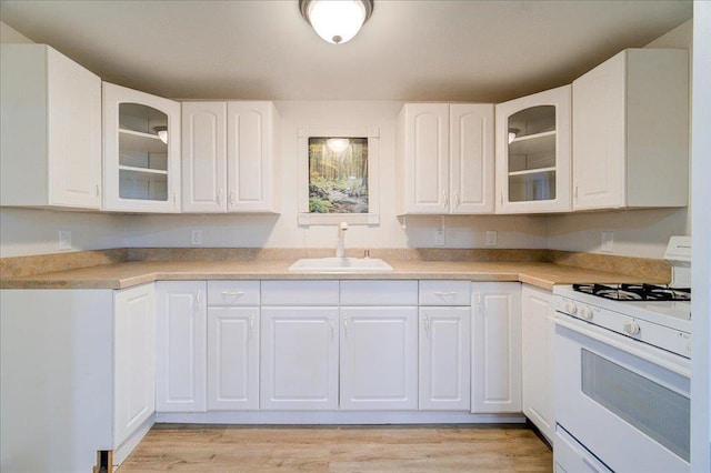 665 State Route 94 N, Warwick, NY 10990 - kitchen with white gas range oven, a sink, white cabinetry, and light wood finished floors