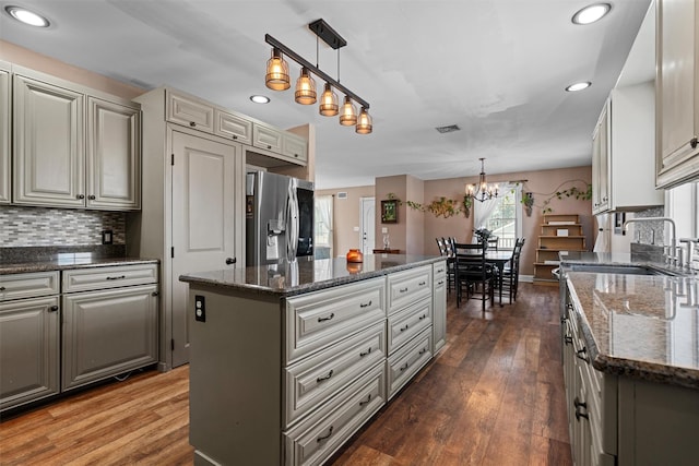 203 Highland Ave, Middletown, NY 10940 - kitchen with stainless steel fridge with ice dispenser, a chandelier, a kitchen island, decorative backsplash, and recessed lighting