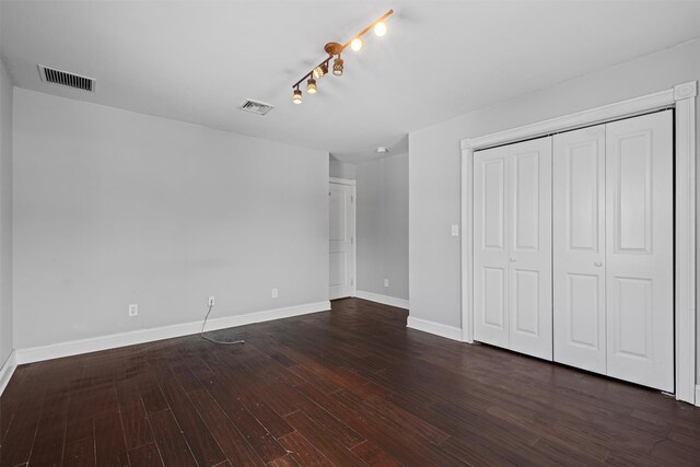 203 Highland Ave, Middletown, NY 10940 - unfurnished bedroom featuring baseboards, dark wood-style floors, a closet, and track lighting
