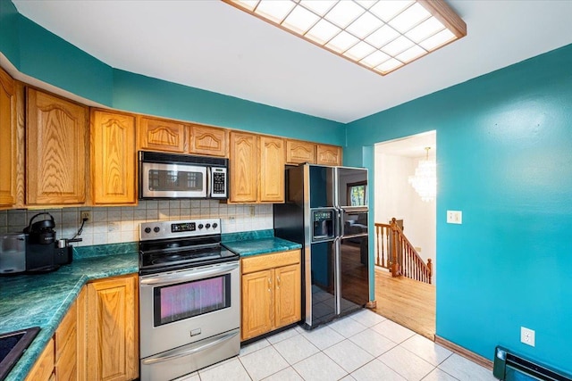 184 Mt Prosper Rd, Wurtsboro, NY 12790 - kitchen featuring stainless steel appliances, decorative backsplash, dark countertops, light tile patterned floors, and a baseboard heating unit
