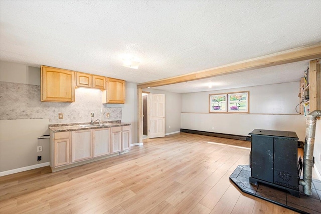 184 Mt Prosper Rd, Wurtsboro, NY 12790 - kitchen with a wood stove, light brown cabinetry, a sink, light wood-style floors, and a textured ceiling
