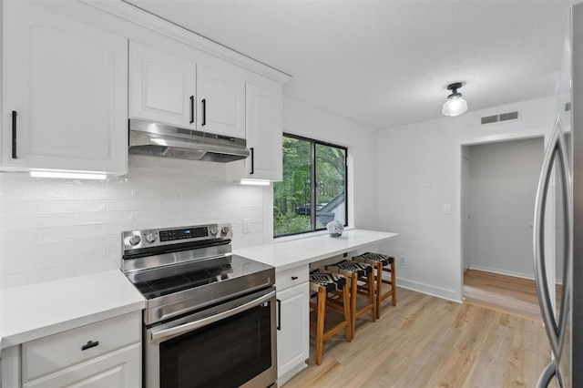 348 Heritage Hls Unit A, Somers, NY 10589 - kitchen with appliances with stainless steel finishes, under cabinet range hood, backsplash, and white cabinets