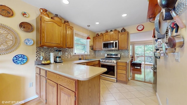 50 Snowden Ave, Ossining, NY 10562 - kitchen with appliances with stainless steel finishes, a peninsula, tasteful backsplash, a sink, and light countertops