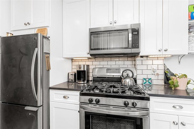 4265 Webster Ave Unit 3H, Bronx, NY 10470 - kitchen with stainless steel appliances, dark countertops, tasteful backsplash, and white cabinets