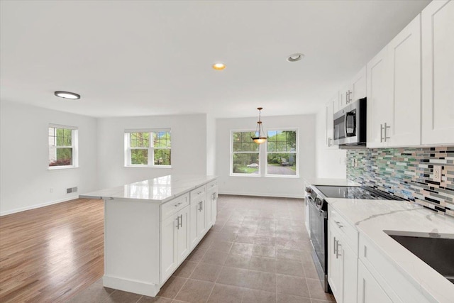 145 Underhill Ln Unit 145, Peekskill, NY 10566 - kitchen featuring appliances with stainless steel finishes, tasteful backsplash, baseboards, light stone counters, and white cabinets