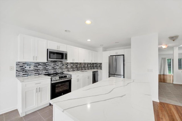 145 Underhill Ln Unit 145, Peekskill, NY 10566 - kitchen with stainless steel appliances, a sink, tasteful backsplash, baseboards, and recessed lighting