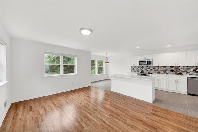 145 Underhill Ln Unit 145, Peekskill, NY 10566 - kitchen with appliances with stainless steel finishes, a sink, white cabinetry, decorative backsplash, and open floor plan
