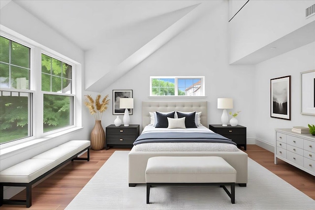 145 Underhill Ln Unit 145, Peekskill, NY 10566 - bedroom featuring multiple windows, wood finished floors, high vaulted ceiling, and baseboards