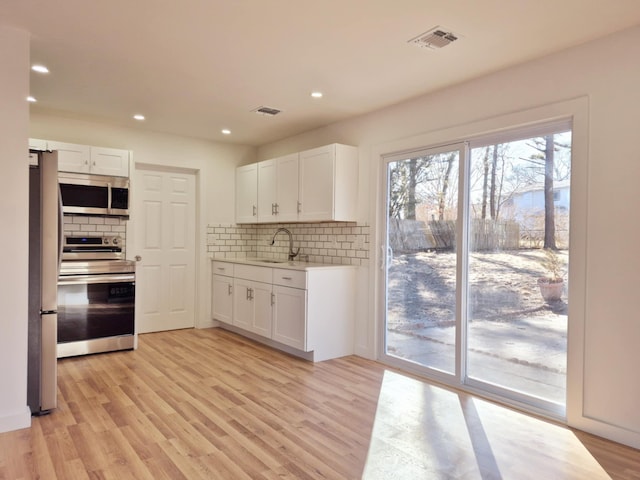 52 Nottingham Dr, Middle Island, NY 11953 - kitchen with appliances with stainless steel finishes, a sink, decorative backsplash, light countertops, and recessed lighting