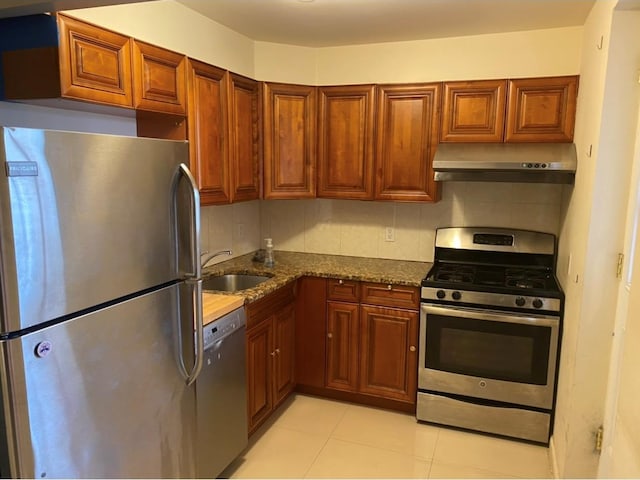 86 Canal St, New York Manhattan, NY 10002 - kitchen featuring appliances with stainless steel finishes, under cabinet range hood, a sink, tasteful backsplash, and light tile patterned floors
