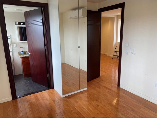 86 Canal St, New York Manhattan, NY 10002 - corridor featuring an AC wall unit, wood finished floors, and baseboards