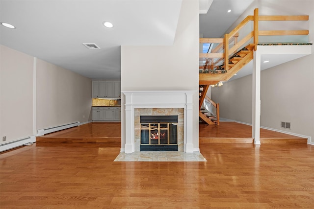 6 Chippewa Ct, Suffern, NY 10901 - unfurnished living room with stairway, baseboard heating, a fireplace, wood finished floors, and recessed lighting
