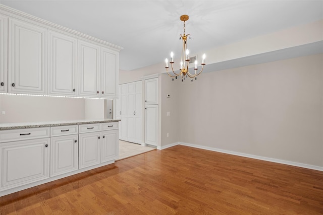 6 Chippewa Ct, Suffern, NY 10901 - spare room with a chandelier, light wood finished floors, and baseboards
