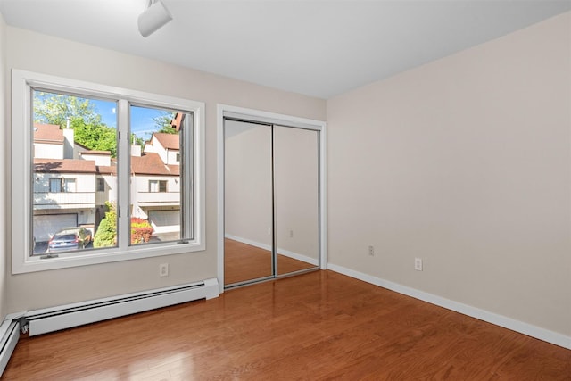 6 Chippewa Ct, Suffern, NY 10901 - unfurnished bedroom featuring wood finished floors, a baseboard radiator, baseboards, and a closet