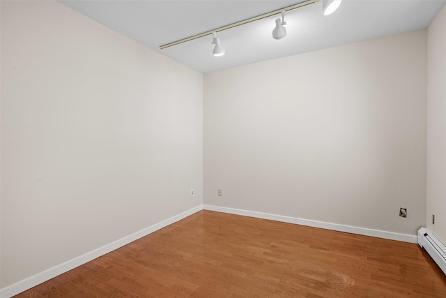 6 Chippewa Ct, Suffern, NY 10901 - empty room featuring a baseboard heating unit, rail lighting, light wood-type flooring, and baseboards