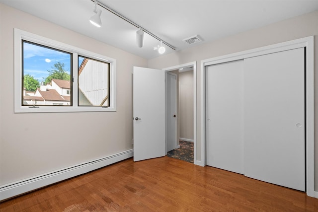 6 Chippewa Ct, Suffern, NY 10901 - unfurnished bedroom featuring baseboard heating, wood finished floors, rail lighting, and a closet