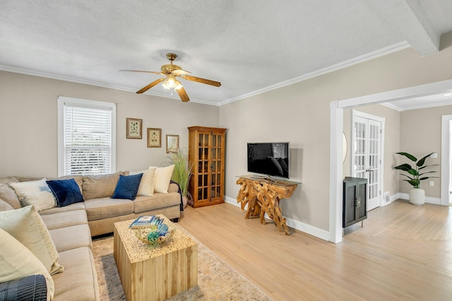 312 5th Ave, Greenport, NY 11944 - living room with light wood finished floors, ceiling fan, crown molding, french doors, and baseboards