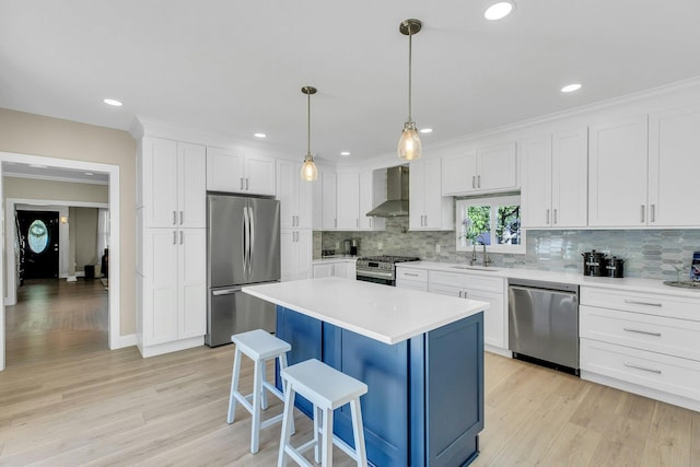 312 5th Ave, Greenport, NY 11944 - kitchen featuring stainless steel appliances, wall chimney exhaust hood, a sink, a breakfast bar area, and decorative backsplash