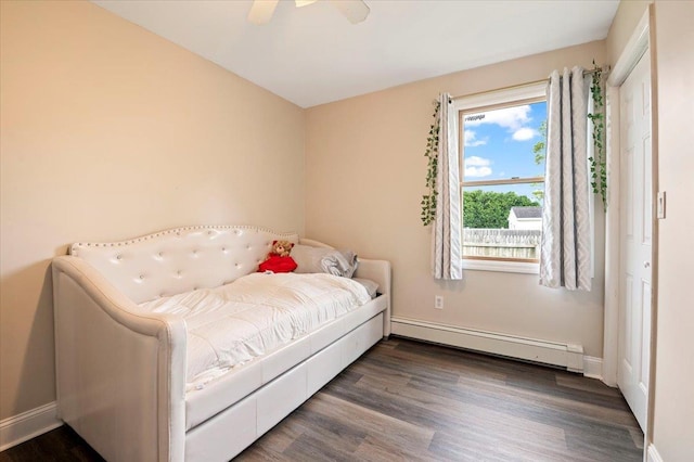 12 Midwood Pl, Farmingville, NY 11738 - bedroom with baseboard heating, dark wood-type flooring, baseboards, and a ceiling fan