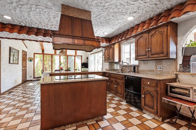 kitchen with black appliances, a sink, light stone countertops, and a kitchen island