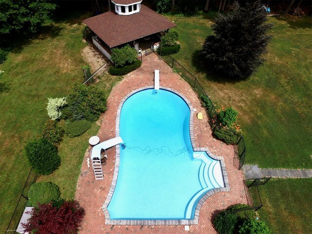 view of pool featuring a water slide and a yard