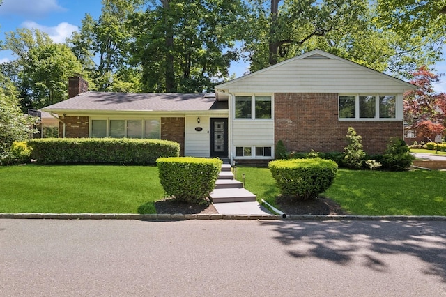 18 Woodcrest Rd, Kings Point, NY 11024 - split level home featuring brick siding, a front lawn, and a chimney