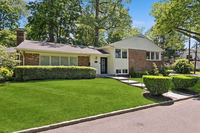 18 Woodcrest Rd, Kings Point, NY 11024 - split level home featuring a chimney, a front lawn, and brick siding