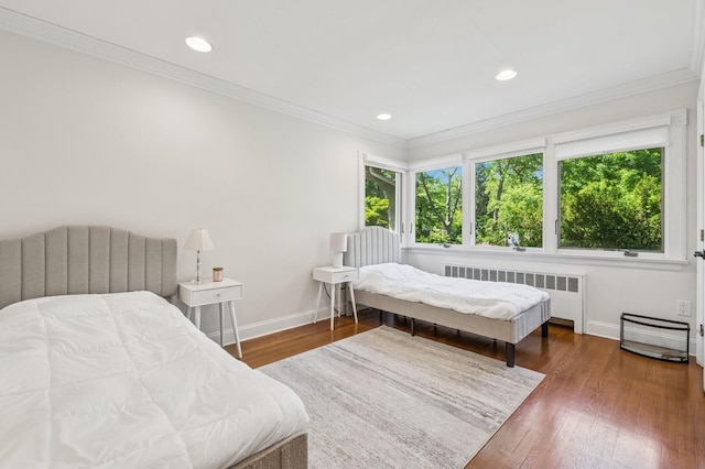 18 Woodcrest Rd, Kings Point, NY 11024 - bedroom with radiator heating unit, multiple windows, baseboards, wood finished floors, and ornamental molding