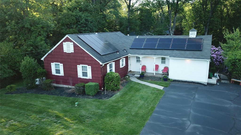 158 Parrott Rd, West Nyack, NY 10994 - view of front facade with a front yard, roof mounted solar panels, roof with shingles, and a chimney