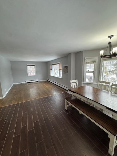 158 Parrott Rd, West Nyack, NY 10994 - unfurnished dining area with baseboard heating, a baseboard radiator, dark wood-type flooring, a chandelier, and baseboards