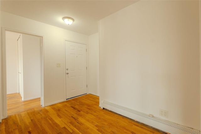 8 Florence Ave Unit 16C, Freeport, NY 11520 - unfurnished room featuring a baseboard heating unit, light wood finished floors, and baseboards