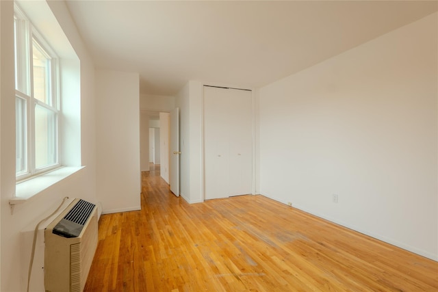 8 Florence Ave Unit 16C, Freeport, NY 11520 - empty room with light wood-style floors, an AC wall unit, baseboards, and heating unit